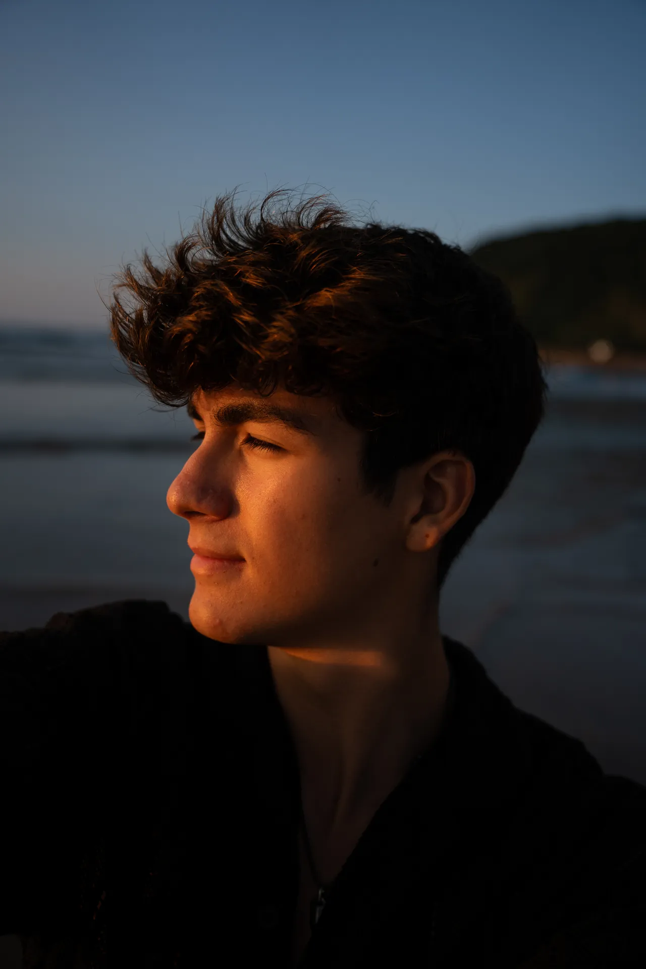 Retrato de Lucas al atardecer junto al mar, con luz lateral cálida