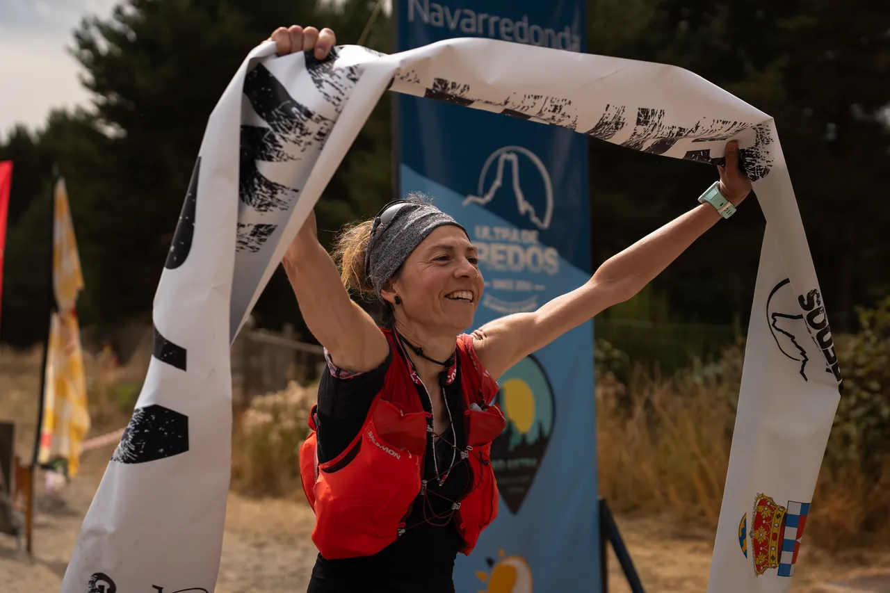 Corredora celebrando con la cinta de meta en el Ultra Trail de Gredos